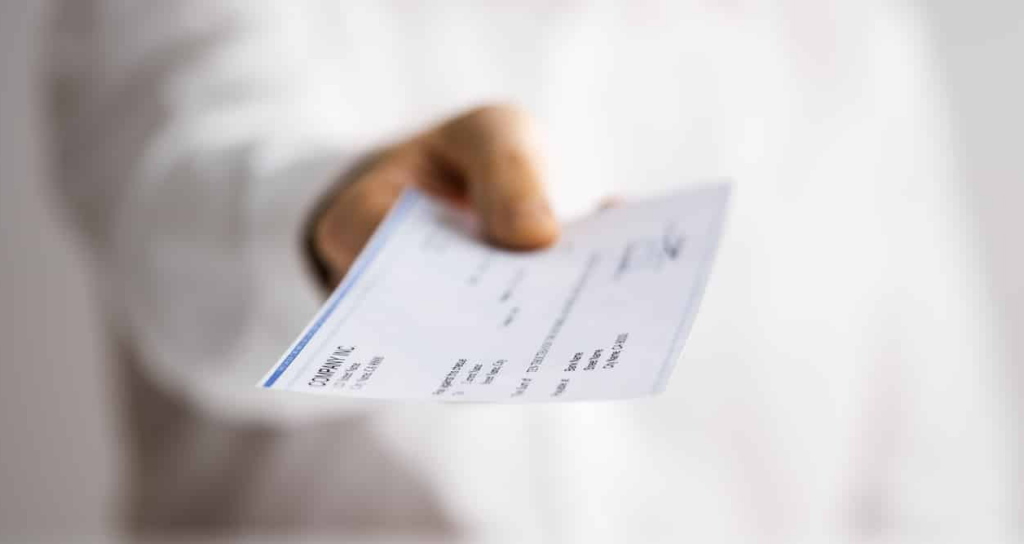 Closeup of a man holding a paycheck