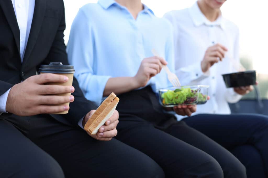 Business people having lunch together outdoors, closeup